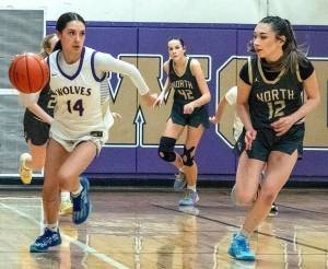 Sequim's Gracie Chartraw (14) scored 34 points to help lead the Wolves to a 66-40 over league rival North Kitsap on Friday. In on this play are North Kitsap's Addison Jess (42) and Jasmine Sunnenberg (12). (Emily Mathiessen/for Peninsula Daily News)