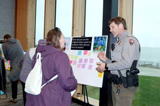 April Messenger, left, and Olympic National Park Ranger Chris Erickson share ideas on Wednesday during a listening session at Field Arts & Events Hall in Port Angeles. Nearly 150 people provided feedback about a new Hurricane Ridge Lodge project following the 2023 fire that destroyed the original structure. Nine easels were set up with questions and notes were provided for people to express their goals for a new lodge. The earliest construction can begin is in 2028, and it would take two to three years to complete, weather permitting. (Dave Logan/for Peninsula Daily News)