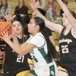 Port Angeles' Kenzie Moses is defended by Bainbridge Island's Jordan Gardner (21) and Allie Paulson-Houser (25) on Tuesday in Port Angeles. Moses had a 3-pointer as the Roughriders won 53-46 to remain unbeaten in the Olympic League. (Dave Logan/for Peninsula Daily News)