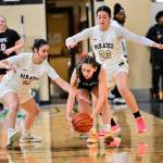 Peninsula Colleges Ryana Moss (11) and Aspen Fraser (23) surround an Olympic player during the Pirates 94-47 victory Saturday in Port Angeles. (Jay Cline/Peninsula College)