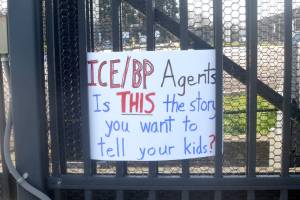 A sign is placed at the entrance of the Border Patrol Station in Port Angeles during a protest on Sunday. (Elijah Sussman/Peninsula Daily News)