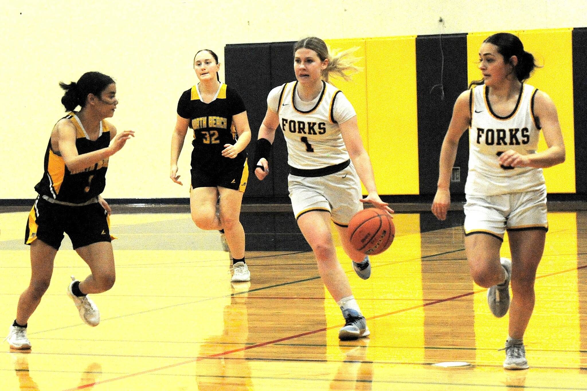 Forks Bailey Johnson brings the ball up the floor against North Beach on Friday in Forks with teammate Skye Hestand. Johnson, despite a broken wrist, scored 25 points in a 67-25 victory. (Lonnie Archibald/for Peninsula Daily News)