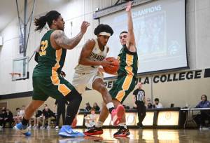 Photos by Jay Cline/Peninsula College Athletics 
Peninsulas Sam Tekeste steps through a pair of Shoreline defenders on his way to the rim during the Pirates 75-63 win over the Dolphins on Wednesday.