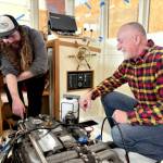 Northwest School of Wooden Boatbuilding Board President Richard Schwarz gets a rundown of the systems installed in a lobster boat built on campus by Iain Rainey, a recent graduate and current Marine Systems Prothero intern. (Northwest School of Wooden Boatbuilding)
