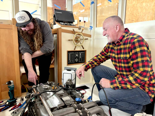 Northwest School of Wooden Boatbuilding Board President Richard Schwarz gets a rundown of the systems installed in a lobster boat built on campus by Iain Rainey, a recent graduate and current Marine Systems Prothero intern. (Northwest School of Wooden Boatbuilding)