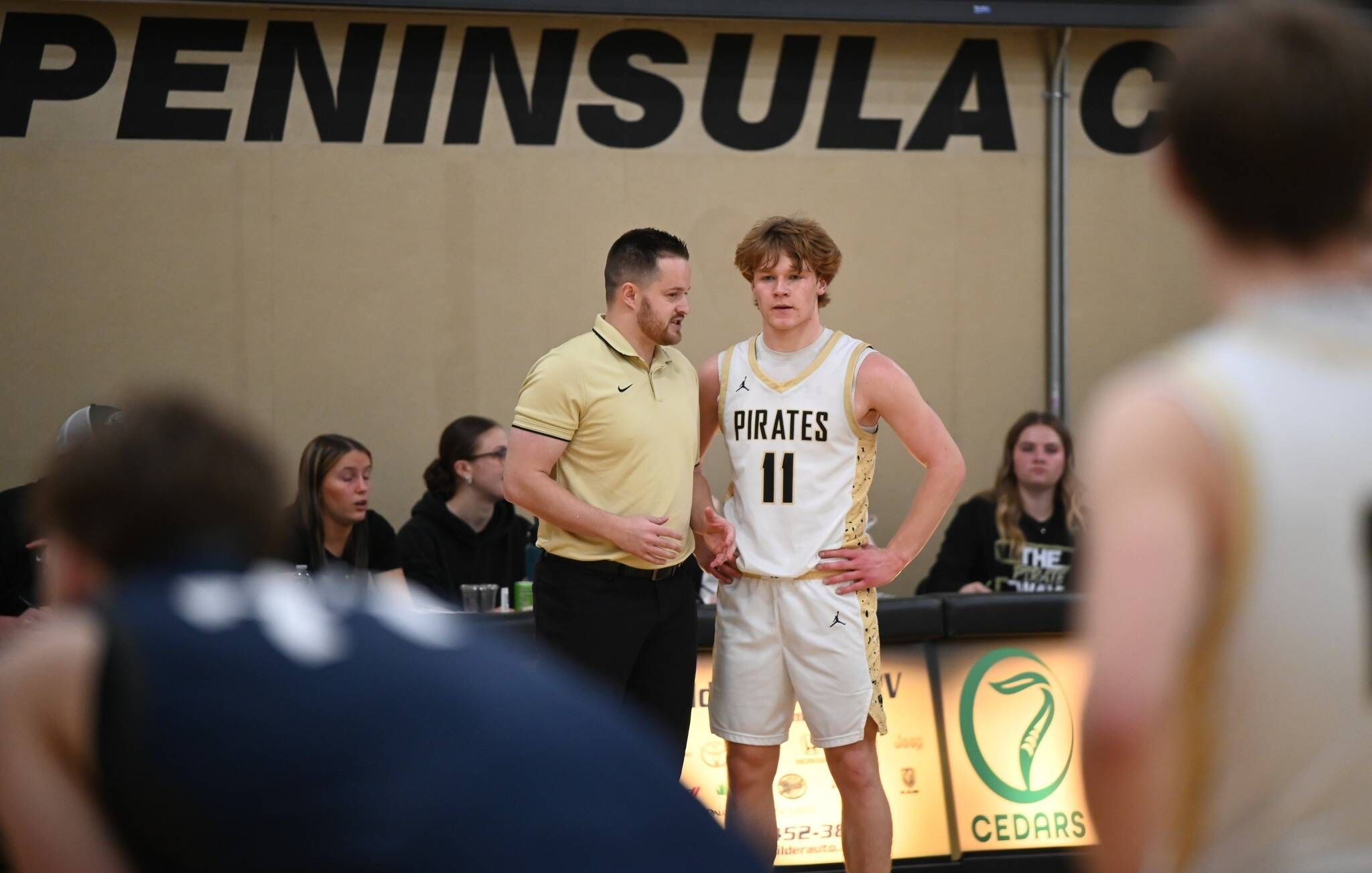 Jay Cline/Peninsula College Athletics
Peninsula College head coach AJ DeMond discusses strategy with Pirate guard Gus Halberg, a Port Angeles alum, during Peninsula's 74-54 loss to first-place Bellevue at home Wednesday.