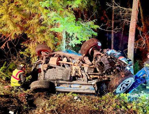 Emergency responders work at the scene Sunday night after a driver crossed the centerline just east of Sequim and collided head-on with another vehicle. One person died and two others were injured in the incident. (Clallam County Fire District 3 via Facebook)