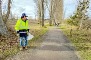 Ed Mead, the official caretaker at Kah Tai Lagoon Nature Park in Port Townsend, takes a moment out of his rounds of cleaning up litter on the pathways on Monday to watch a flock of ducks that had landed in the lagoon to his left. Mead moved to Port Townsend from California to be closer to his grandkids. The city of Port Townsend owns the nearly 76-acre park. (Steve Mullensky/for Peninsula Daily News)