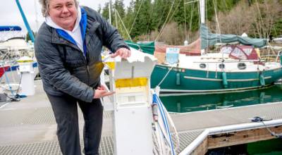 Kori Ward, marina director at Port Ludlow Marina, shows off one of the 28 new GFI pedestals installed on the private dock at the marina in order to comply with a new state electrical code requiring ground-fault protection at marinas. The code, effective Jan. 1, mandates that every vessel must be able to plug into shore power without tripping a marinas ground fault breakers. (Steve Mullensky/for Peninsula Daily News)