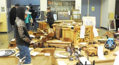 Rhett LeDuke, 9, of Beaver looks over a few of the many items available for bidding during the 62nd Quillayute Valley Scholarship Auction at Forks High School commons on last weekend. The annual auction raised $175,750 for the scholarship program, which typically awards 50 to 60 scholarships for four-year colleges, two-year colleges, technical certification programs and apprenticeships to graduating seniors at Forks High School and the Quileute Tribal School. (Lonnie Archibald/for Peninsula Daily News)