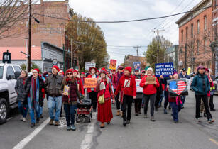 The Port Townsend Resistance Choir marches down Water Street in downtown Port Townsend during the No Kings rally on Saturday. (Steve Mullensky/for Peninsula Daily News)