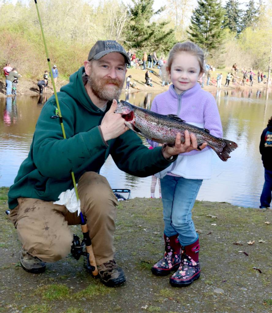 Dave Logan/for Peninsula Daily News
Morgan Duffy of Port Angeles, has her dad Joshua Duffy hold the fish she caught at the 2025 Kids Fishing Derby at Lincoln Park. The 2026 edition of the derby is set for Saturday at Lincoln Park. Sequims Kid Fishing Day is set for April 18 at Carrie Blake Park.