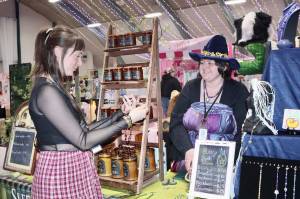 Brianna Van Blair, left, talks with Audrey Gentzler of Sequim in a booth called Starry Spell on Thursday during the first of a four-day run of the Squatchon Comic and Arts Convention at the Vern Burton Center in Port Angeles. Squatchcon continues through Sunday. (Dave Logan/for Peninsula Daily News)