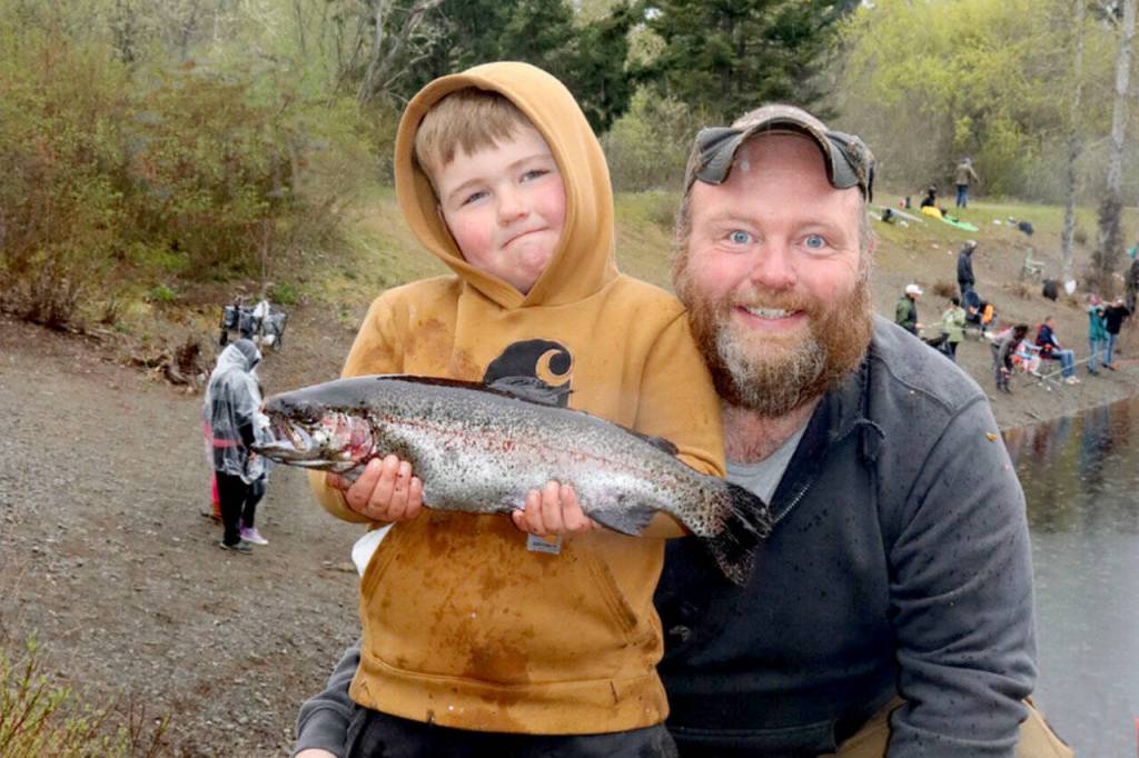 Landon Fry, 5, along with his dad Tim Fry, shows off his winning 19-inch fish that he caught Saturday at the 2026 Kids Fishing Derby at Lincoln Park. The fishing derby was sponsored by the Olympic Peninsula Flyfishers, while free hot dogs and drinks were provided by the Kiwanis Club. There were 750 fish planted in the pond and more than 200 kids 12 and younger participated in the derby.
(Dave Logan/for Peninsula Daily News)