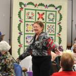 Norma Herbold, co-organizer of the Sunbonnet Sue Quilt Clubs 40th anniversary party, shows off her Safeway after 5 coat she made and wore during the partys Wearable Fashion Show on April 8. (Matthew Nash/Olympic Peninsula News Group)
