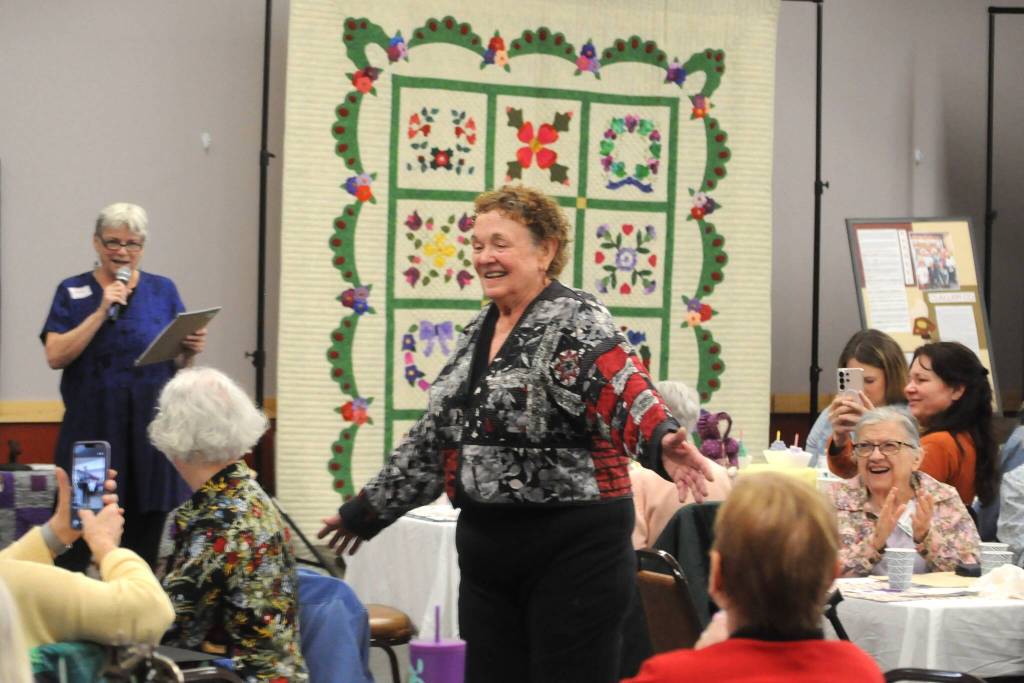 Norma Herbold, co-organizer of the Sunbonnet Sue Quilt Clubs 40th anniversary party, shows off her Safeway after 5 coat she made and wore during the partys Wearable Fashion Show on April 8. (Matthew Nash/Olympic Peninsula News Group)
