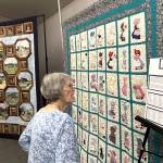 Carol Geer, a longtime Sunbonnet Sue Quilt Club member, looks at the Sunbonnet Sue Friendship Quilt on April 8. She said when she moved back to Sequim years ago, she sought out friends and a quilt group and got both through the club. Through the clubs 40 years, shes found its philanthropic efforts to support the community have been very special. (Matthew Nash/Olympic Peninsula News Group)