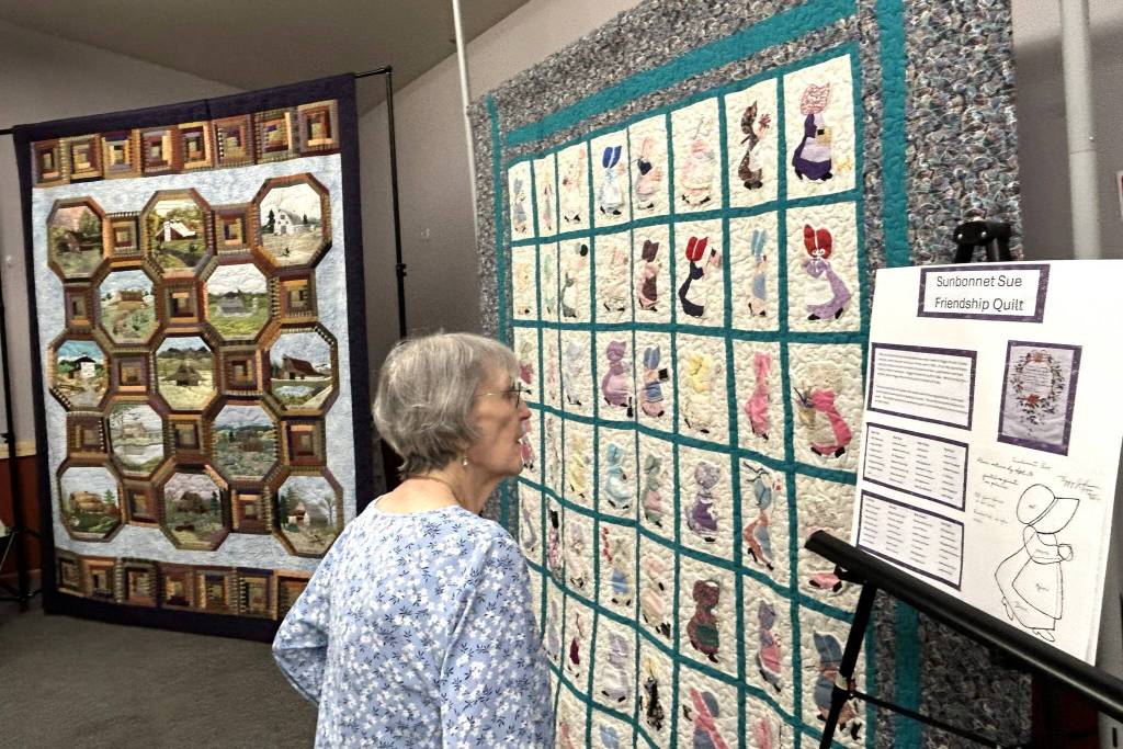 Carol Geer, a longtime Sunbonnet Sue Quilt Club member, looks at the Sunbonnet Sue Friendship Quilt on April 8. She said when she moved back to Sequim years ago, she sought out friends and a quilt group and got both through the club. Through the clubs 40 years, shes found its philanthropic efforts to support the community have been very special. (Matthew Nash/Olympic Peninsula News Group)