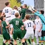 Port Angeles goalkeeper Maverick Williams (in blue jersey) battles for a loose ball in front of the Roughriders goal. Williams made numerous saves in a 2-1 loss to Bainbridge, the No. 1-ranked team in the state. (Jay Cline/for Peninsula Daily News)