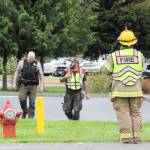 Law enforcement officers, fire personnel and medics walk the grounds Wednesday after a shooting threat was located on a bathroom wall at Forks Middle School. (Lonnie Archibald/for Peninsula Daily News)