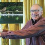Don Berger, the only member with college rowing experience when the Sequim Bay Yacht Club established a rowing program 10 years ago, poses with a picture of himself at the clubs 50th anniversary dinner. (Emily Matthiessen/for Olympic Peninsula News Group)