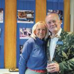 Marian and Jerry Fine, vice commodore of the Sequim Bay Yacht Club, pause before a display of images from the early days of the club during the 50th anniversary celebration at John Wayne Marina. (Emily Matthiessen/for Olympic Peninsula News Group)