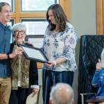 Youth category recipient McHenry Miller, left, accepts a Clallam County Community Service award from nominator Edna Petersen and Eran Kennedy while Cherie Kidd approves on Wednesday during the ceremony at the Port Angeles Senior & Community Center. (Emily Matthiessen/for Peninsula Daily News)