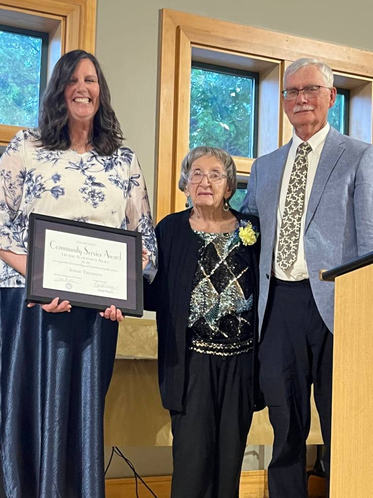 Jerrie Tiderman, 99, center, accepts the first Lifetime Achievement award from Regional Publisher Eran Kennedy on Wednesday during the Clallam County Community Service awards at the Port Angeles Senior & Community Center. (Cynthia Evans)