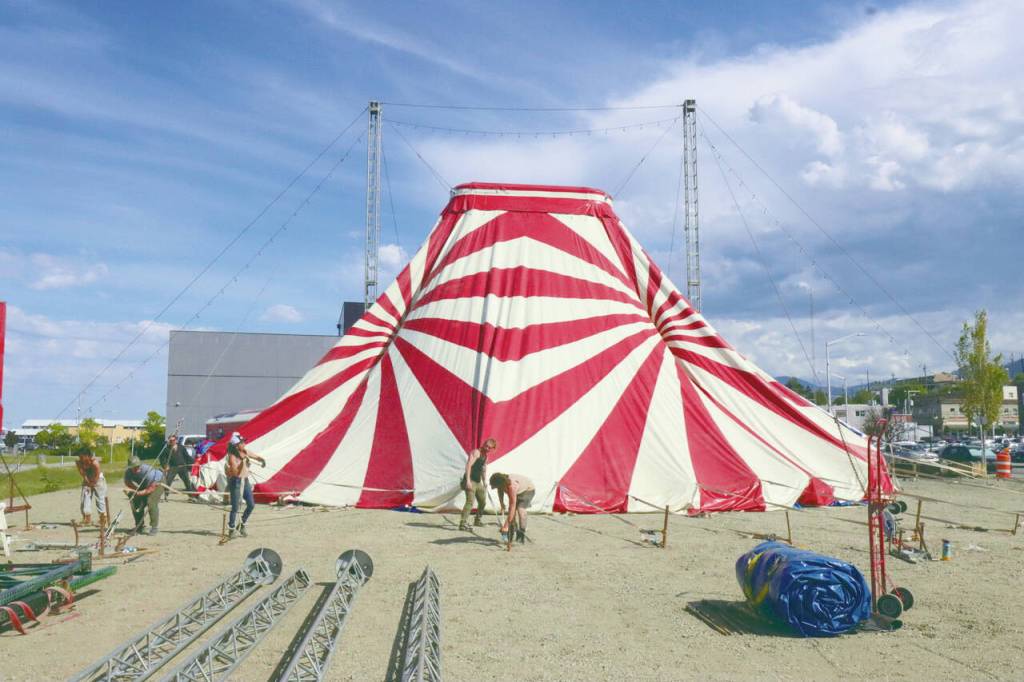 To set up the old-fashioned big top tent, the circus crew has to drive several dozen large spikes into the ground for support. Here, they secure the big top to the spikes. (Dave Logan/For Peninsula Daily News)