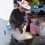 Jay Ramos of the Egg Roll Hut cooks up some chicken for his booth. Ramos is among more than a dozen food vendors, as well as many craftspeople, in the outdoor venue on Fourth Street and the Port Angeles City Hall parking lot for the Juan de Fuca Festival of the Arts. (Dave Logan/For Peninsula Daily News)