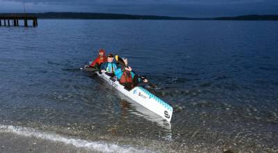 Team Tritons, from left, Dave Jensen of Truckee, Calif., Rich Long of San Clemente, Calif., and Andrew McEwan of White Salmon paddle their Carbonology three-man Surfski the last few meters to the beach at the Northwest Maritime beach to win the annual Seventy48 race from Tacoma to Port Townsend. The 70-mile race started at 7 p.m. Friday and ended at 4:50 a.m. Saturday after nine hours and 50 minutes of continuous paddling. This was the second win in a row for Team Tritons. (Steve Mullensky/for Peninsula Daily News)
