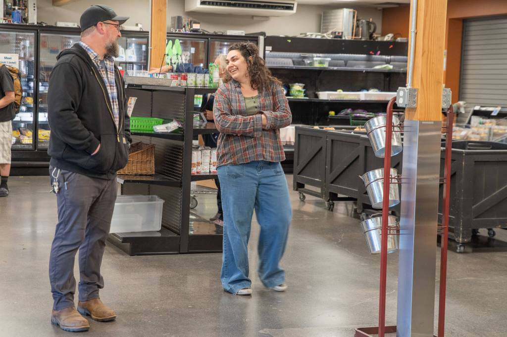 Kevin Perry shares a light moment with Market Manager Analise Graziani inside The Market area of the expansive warehouse at 632 N. Oakridge Drive, Port Angeles. (Emily Mathiessen/Olympic Peninsula News Group)