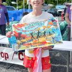 Half-marathon winner Nico Errichetti, 16, of Port Townsend shows off his poster. He is trying to win races at all five Run the Peninsula races. (Pierre LaBossiere/Peninsula Daily News)