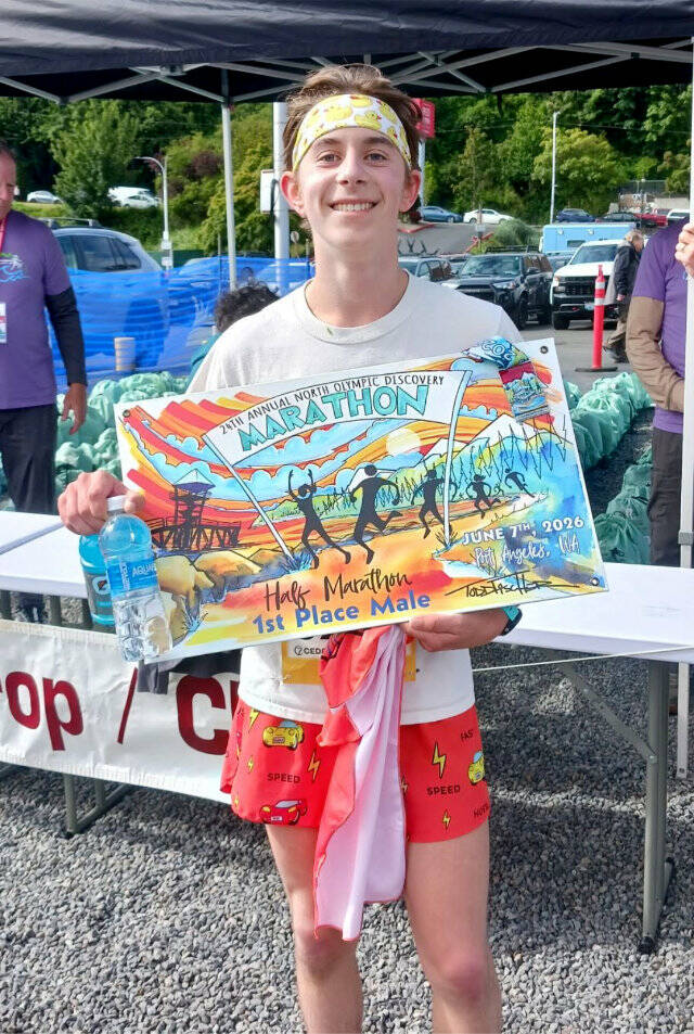 Half-marathon winner Nico Errichetti, 16, of Port Townsend shows off his poster. He is trying to win races at all five Run the Peninsula races. (Pierre LaBossiere/Peninsula Daily News)