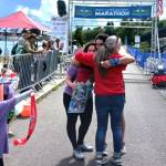 Michael Higuera gets a hug from NODM race officials after winning his first Run the Peninsula race. Higuera consistently finishes in the top five of every race he enters. (Pierre LaBossiere/Peninsula Daily News)