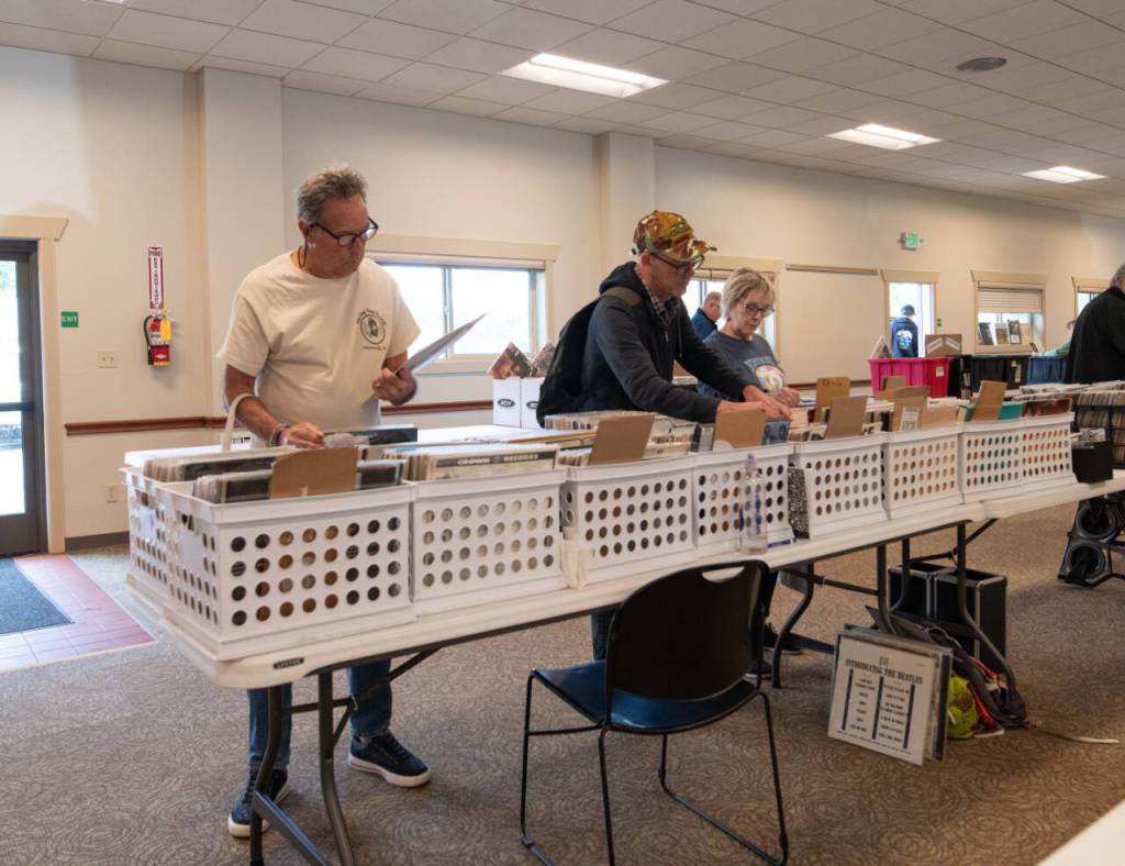 Sequim Gazette photo by Monica Berkseth/ From left, George Mathews of Sequim, John Murphy of Victoria and Lisa Roberts of Sequim browse through records at the fourth annual Sequim Record Show, held Saturday, June 6 at the Guy Cole Event Center at Carrie Blake Community Park. Mathews said he has attended the record show every year.