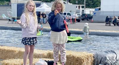 Adaline Hamilton, 9, left, and Eleanor Hagan, 8, take advantage of the wind to blow bubbles on Saturday at the Port Angeles Maritime Festival. The annual Port of Port Angeles event featured a U.S. Coast Guard search and rescue demonstration, tours of port facilities with commissioners Connie Beauvais and Colleen McAleer, the Flounder Pounder Fishing Derby and a Kids Zone with wooden sailboat making and paddle racing. (Paula Hunt/Peninsula Daily News)