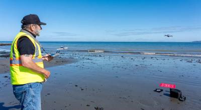 Joe Roubal of Port Townsend, a retired cartographer and programmer, recovers his drone after a 15-minute flight over kelp beds about 400 meters off North Beach in Port Townsend on Wednesday. The drone was programmed to fly a specific route while taking photos every two seconds. Roubal wrote a computer program to process the images for study and mapping. (Steve Mullensky/for Peninsula Daily News)