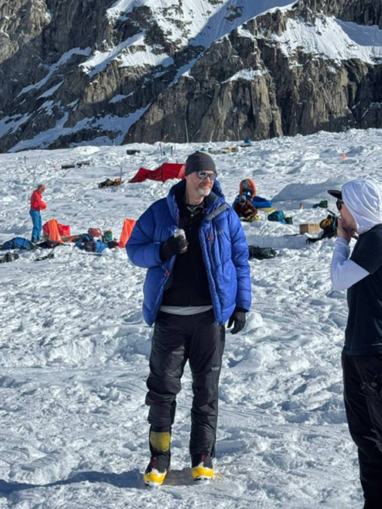 Paul Balkan chats with a fellow climber at the base of Kahiltna Glacier as they wait for a plane to take them back to Talkeetna. Balkan scrambled up peaks in the Olympics while he grew up in Sequim, then moved on to the Cascades with a goal of someday climbing the challenging mountain. (Paul Balkan)