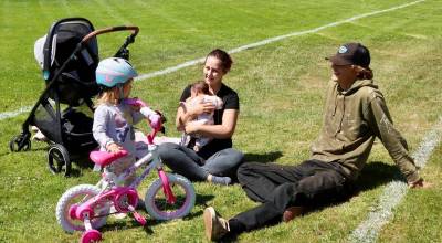 Zach and Crystal Dunger of Port Angeles enjoy summer weather in the grassy field at Shane Park in west Port Angeles on Wednesday with their two children, 2½ year old Lizzie and one month old Jaxton. (Dave Logan/for Peninsula Daily News)