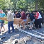 A group carries The Klallam Spirit to Lake Crescent for its first official launch Thursday at the NatureBridge Campus. (Emily Hanson/Peninsula Daily News)