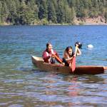 Skylar Wheeler, left, and Valerie Charles paddle the Klallam Spirit on Lake Crescent on Thursday at the NatureBridge Campus. (Emily Hanson/Peninsula Daily News)