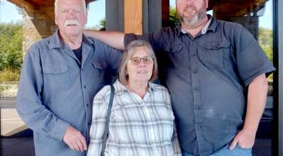 Dale Ridgway, left, and Mike Ridgway, right, posing with Dales wife Margie, are the first father-son to be inducted into the Roughriders Hall of Fame together. (Pierre LaBossiere/Peninsula Daily News)